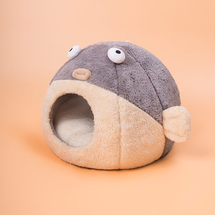 Plush pet bed shaped like a fish with googly eyes on a peach background