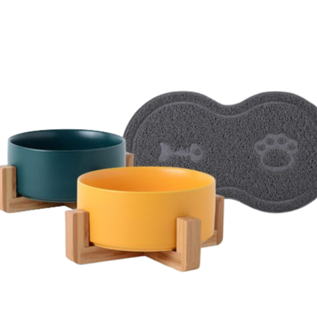 Two ceramic bowls with wooden stands and a gray mat with a paw print on a white background
