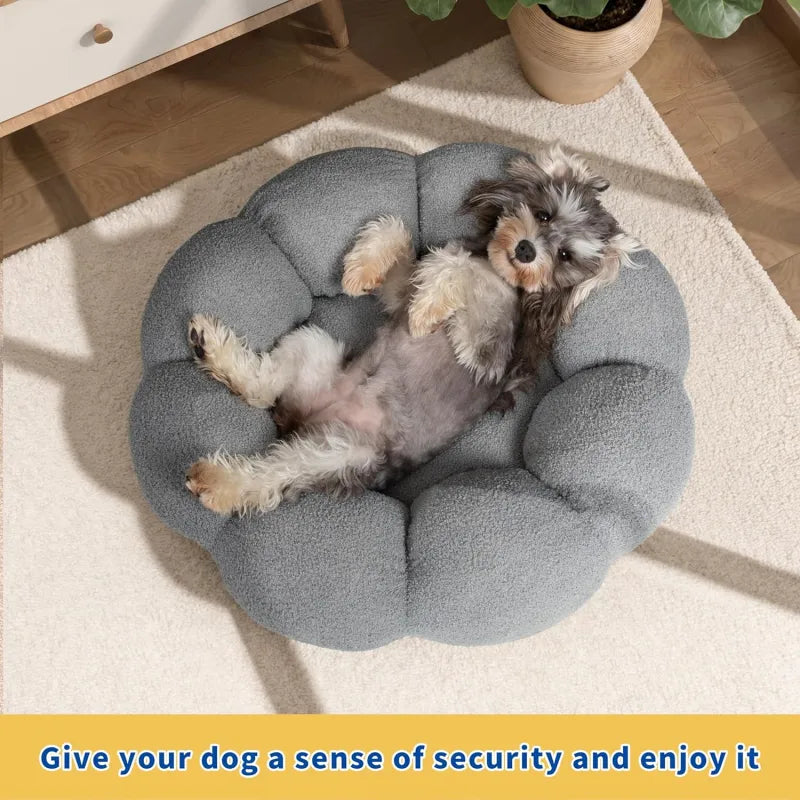 Dog lying on a gray cushioned pet bed with a cozy indoor setting.