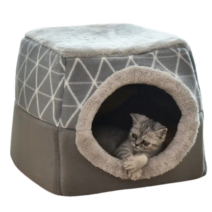 Cat lying inside a geometric-patterned pet house on a white background