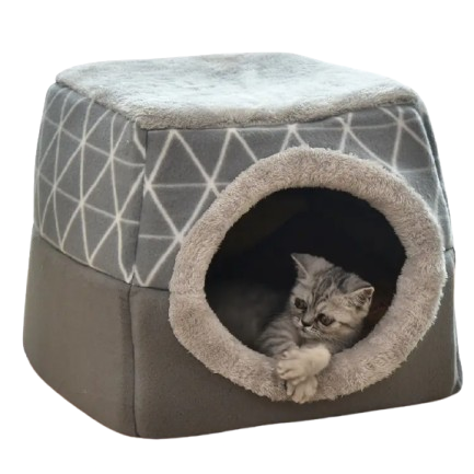 Cat lying inside a geometric-patterned pet house on a white background
