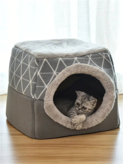 Cat lying inside a geometric-patterned pet bed on a wooden floor.