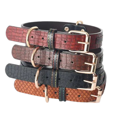 Stack of leather dog collars with gold buckles on a white background