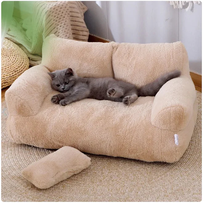 Cat lying on a plush beige pet bed with a soft pillow in a cozy room.